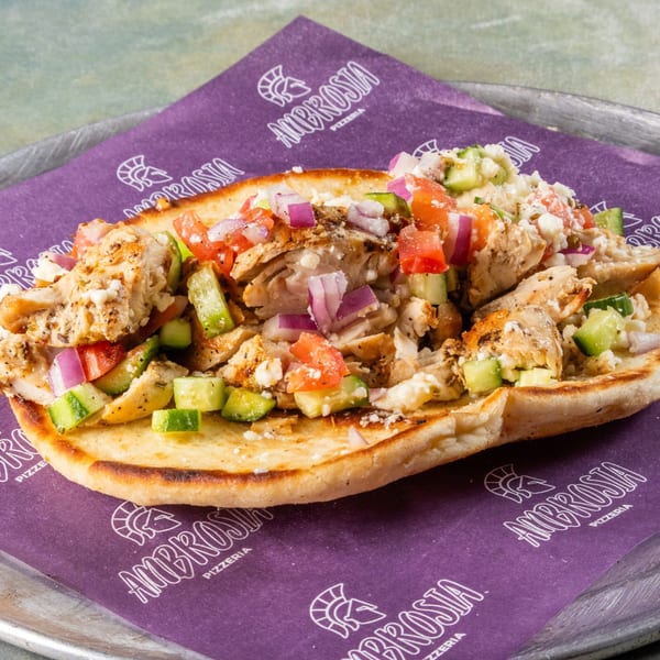 Ambrosia Pizzeria's chicken pita, topped with diced tomatoes, cucumbers, red onions, and feta cheese.